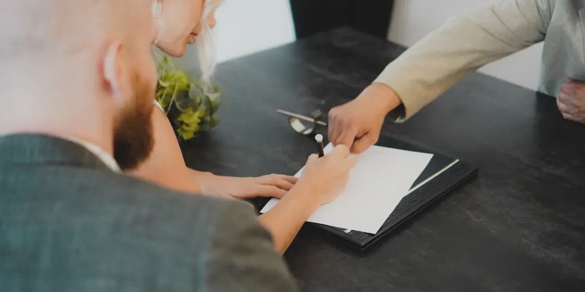 Two people signing incorporation documents at a desk