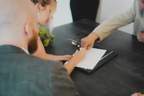 Two people signing incorporation documents at a desk